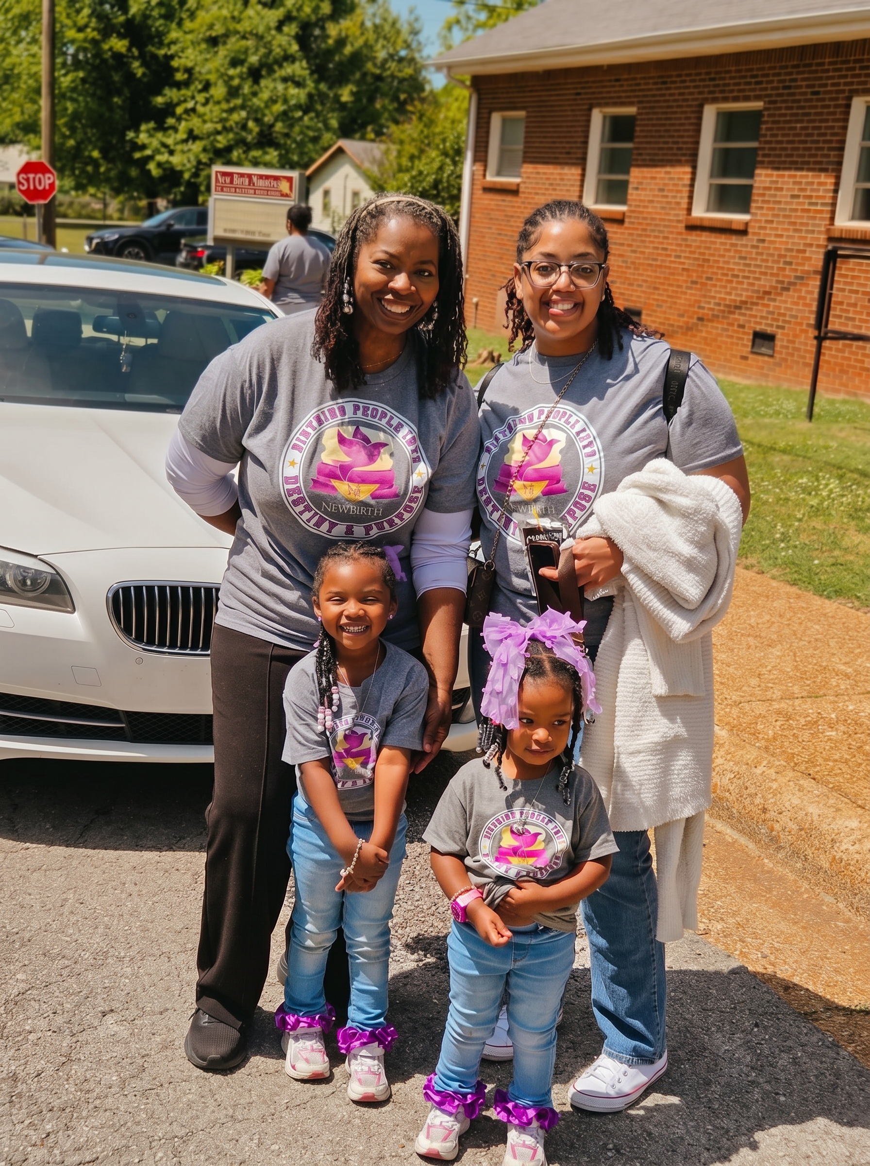 Two mothers and their daughters outside the sanctuary in matching ministry shirts